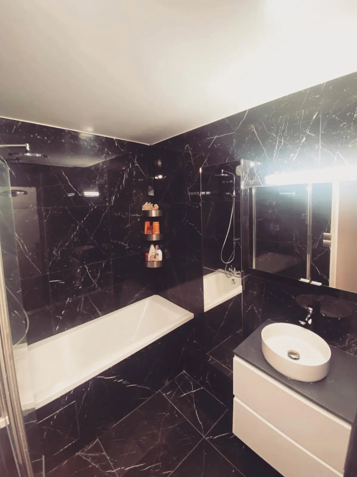 La même salle de bain après rénovation en marbre noir